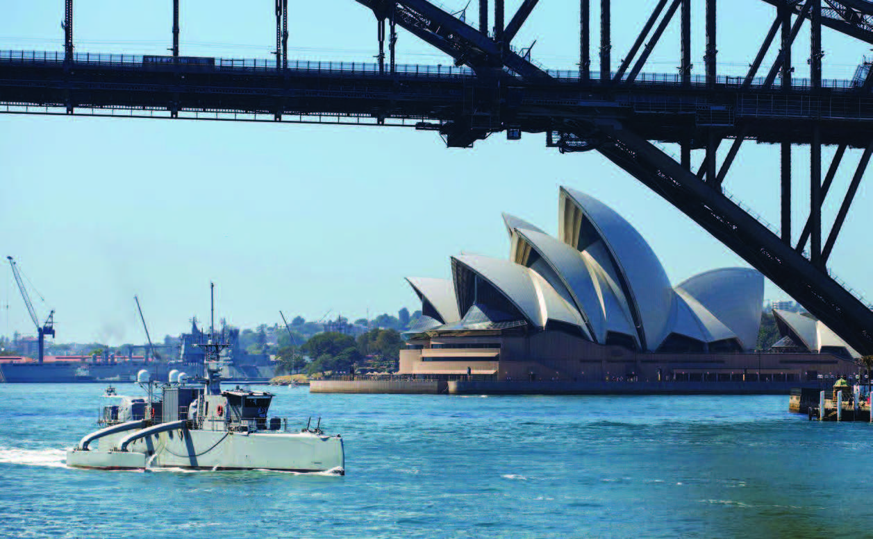 Unmanned surface vessel Sea Hunter transits underneath Sydney Harbor bridge as part of scheduled port visit during Integrated Battle Problem 23.2, October 24, 2023 (U.S. Navy/Pierson Hawkins)